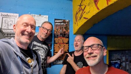 Die Band vor einem frisch aufgehängten Feinstaub-Plakat im Proberaumbunker